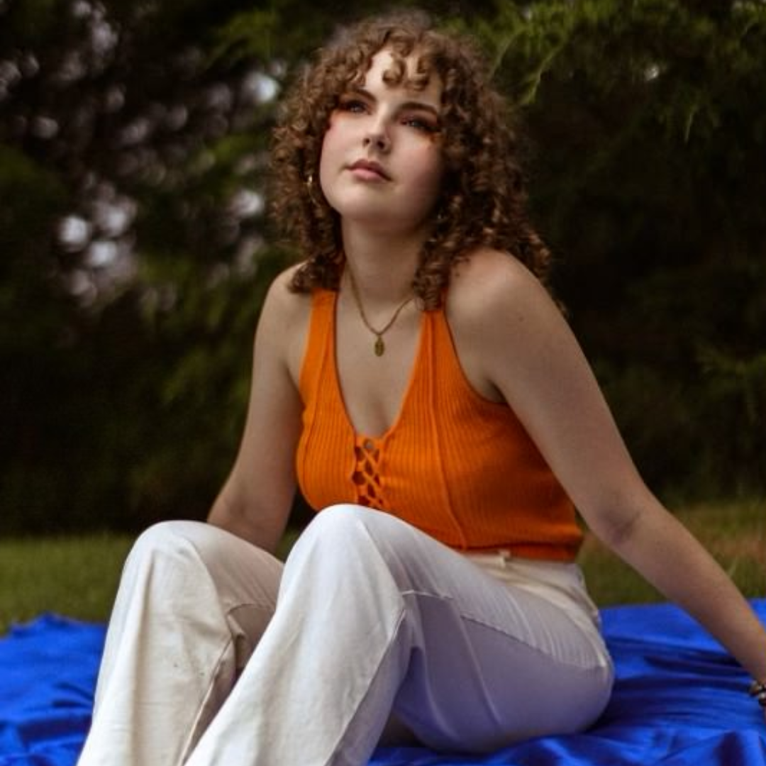 sofia young on a blanket in the grass 