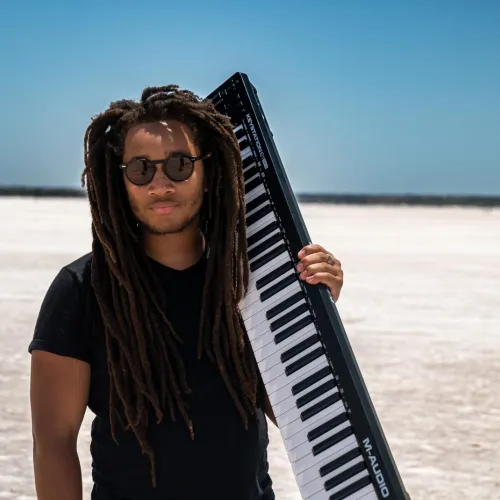 max moore standing on a salt flat holding a keyboard